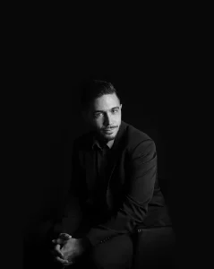 Portrait de Gregory en tenue noire sur fond sombre