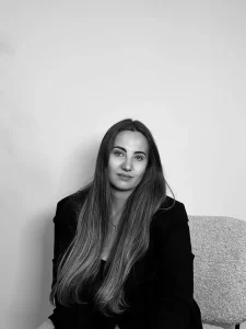 Portrait en noir et blanc de Louna, assise en tenue noire