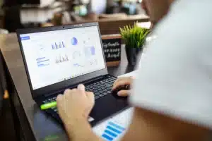 un homme sur son ordinateur entrain d'analyser des graphiques